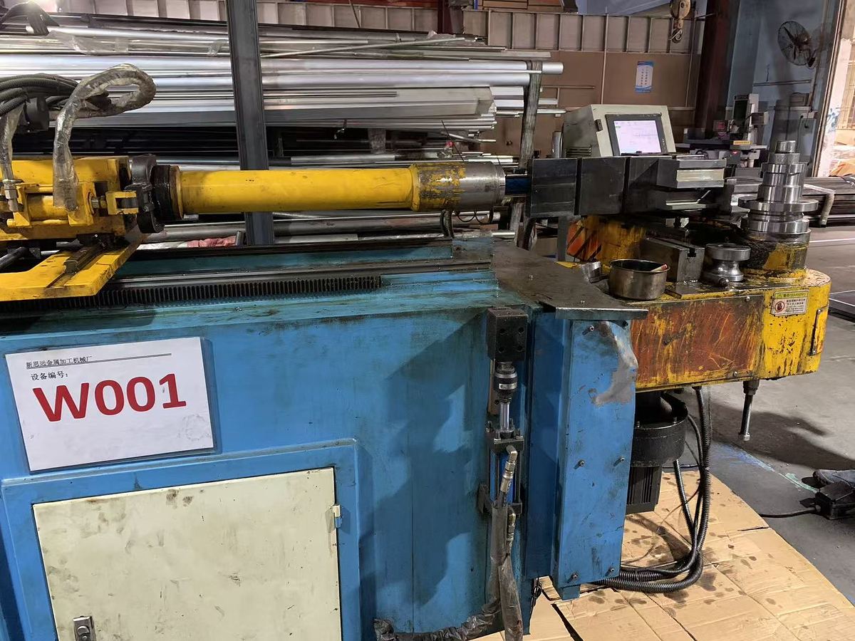 Tube bending machine marked W001 on the shop floor